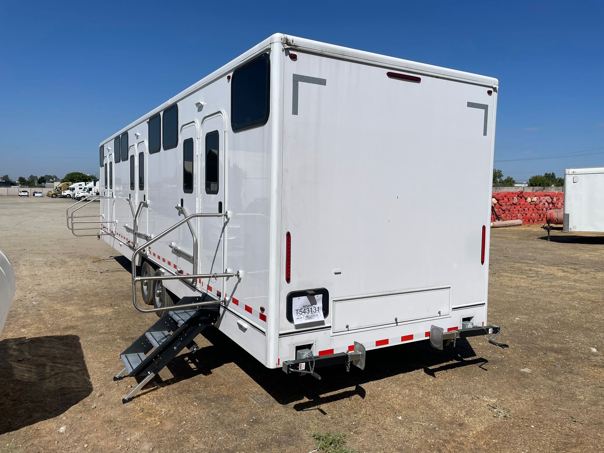 Rear angle of the 34 ft bunkhouse sleeper trailer on a gravel yard