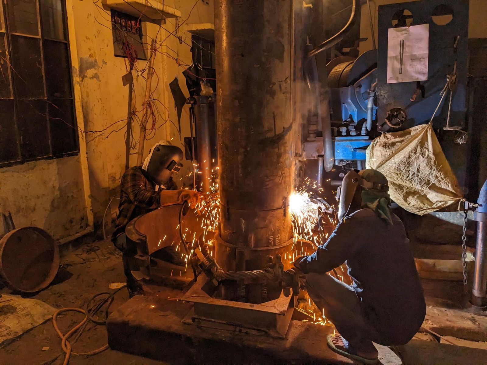 Pipeline welder joining pipe with sparks flying