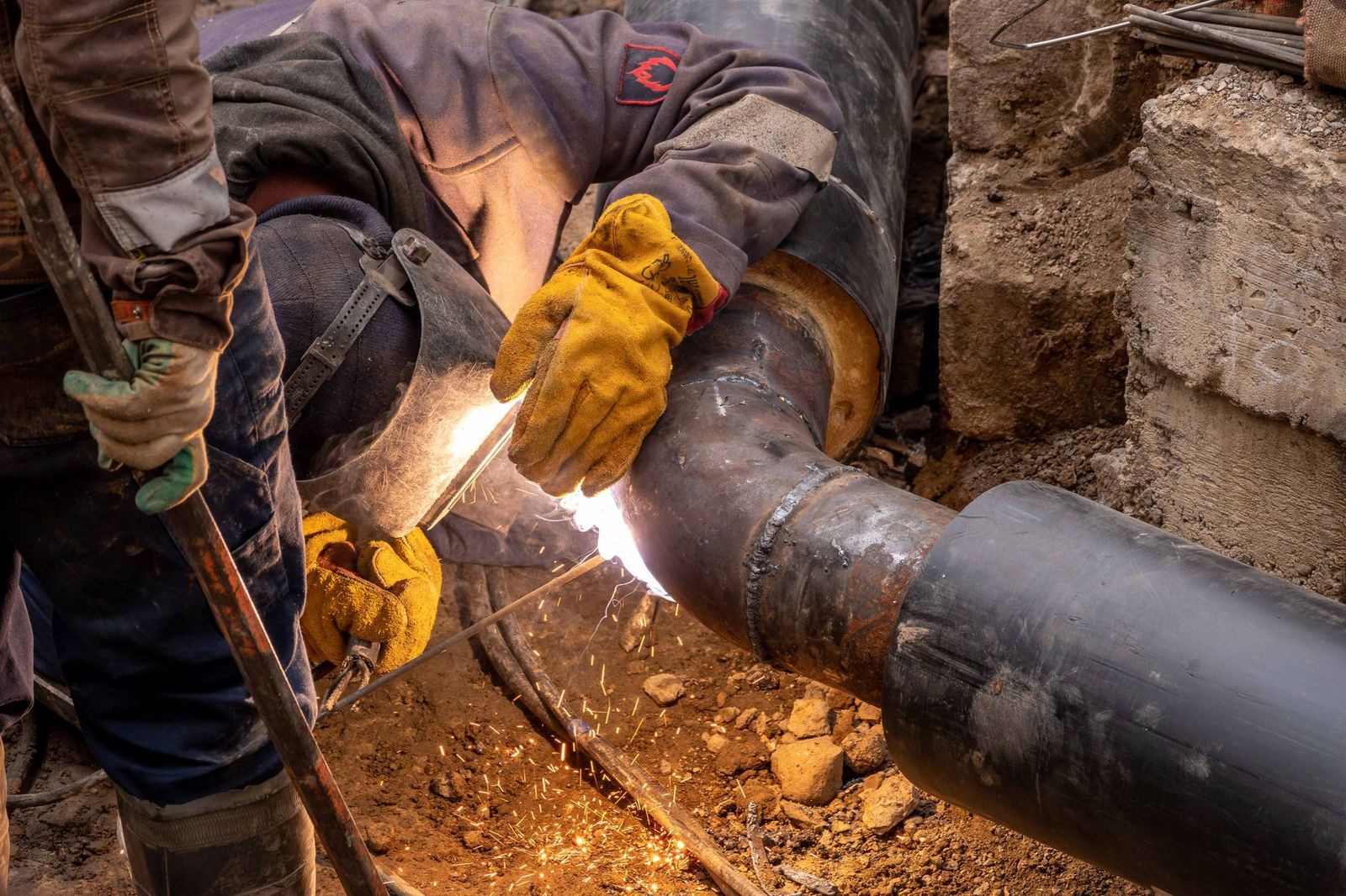 Pipeline welding crew joining pipe outdoors