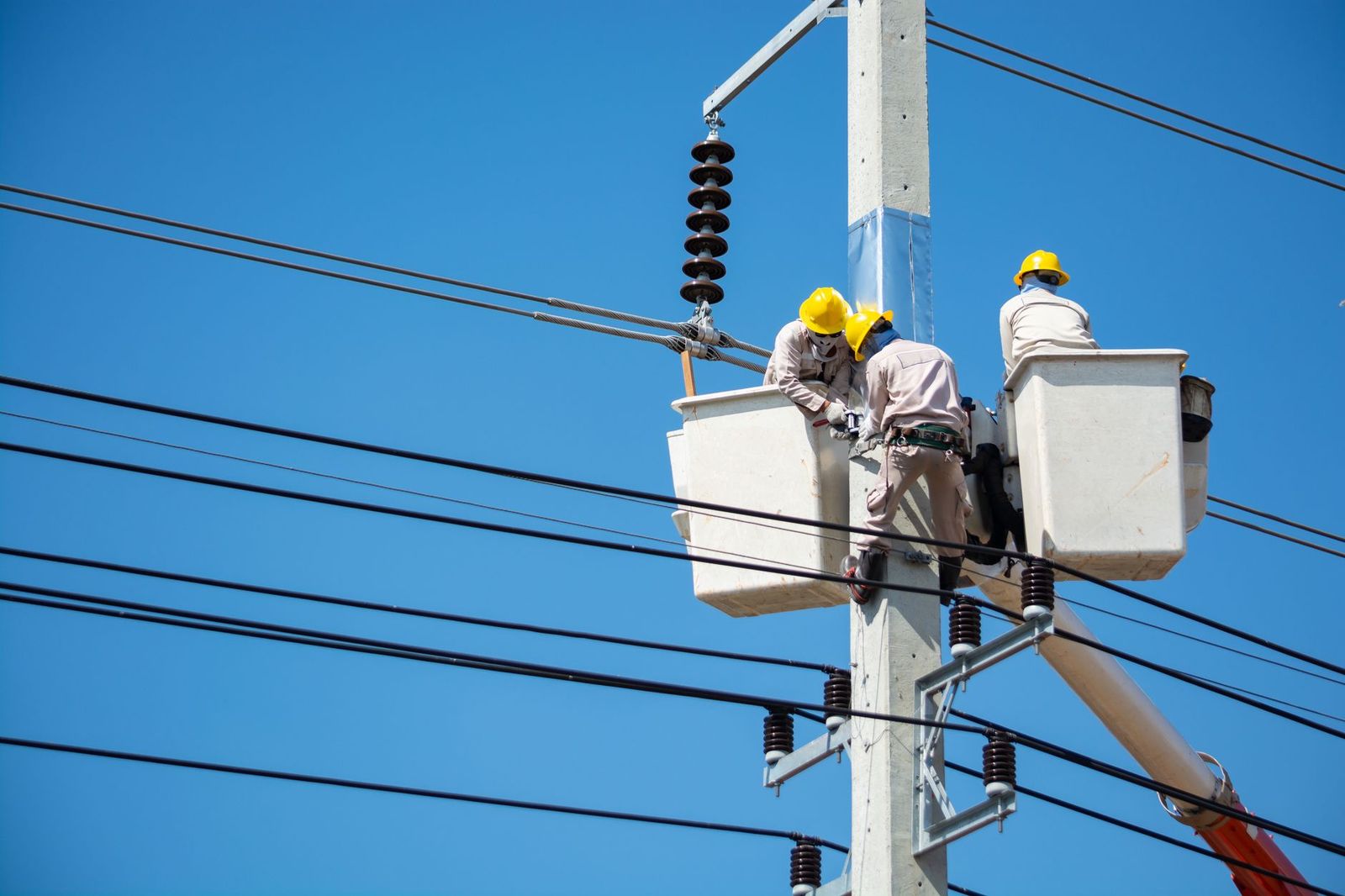 Utility linemen repairing power lines from a bucket truck