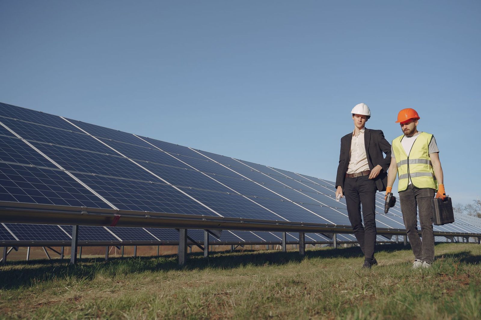 Solar farm engineer walking a panel array