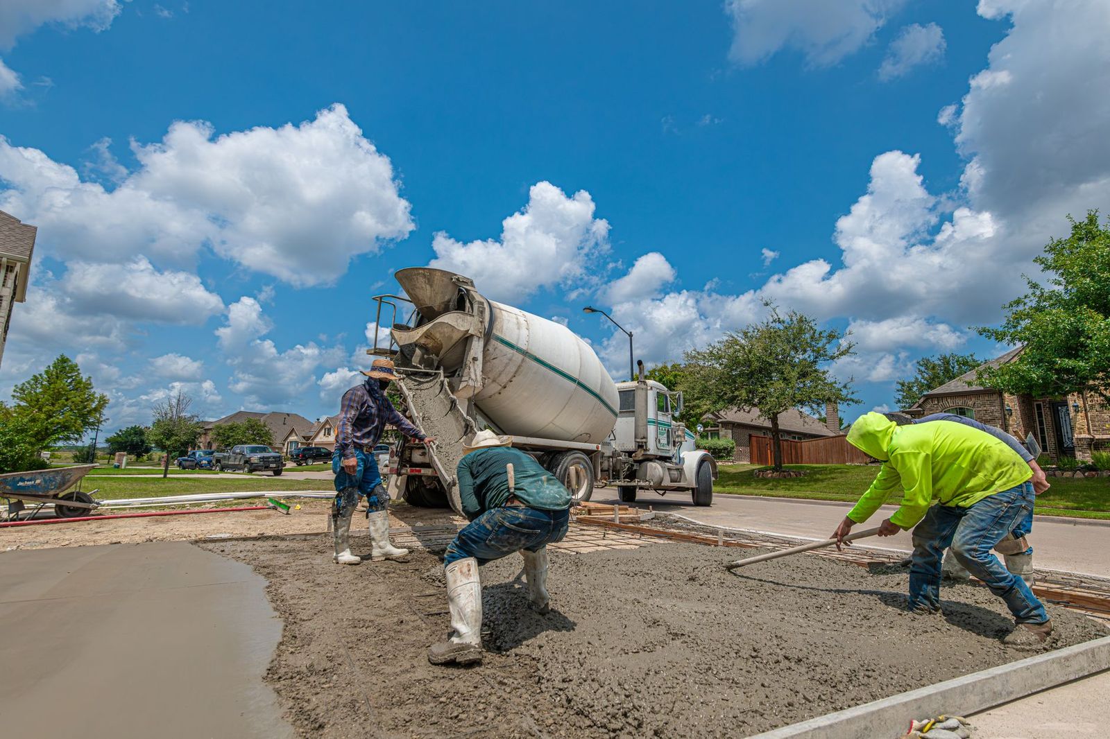 Road crew pouring and finishing concrete paving from a mixer truck