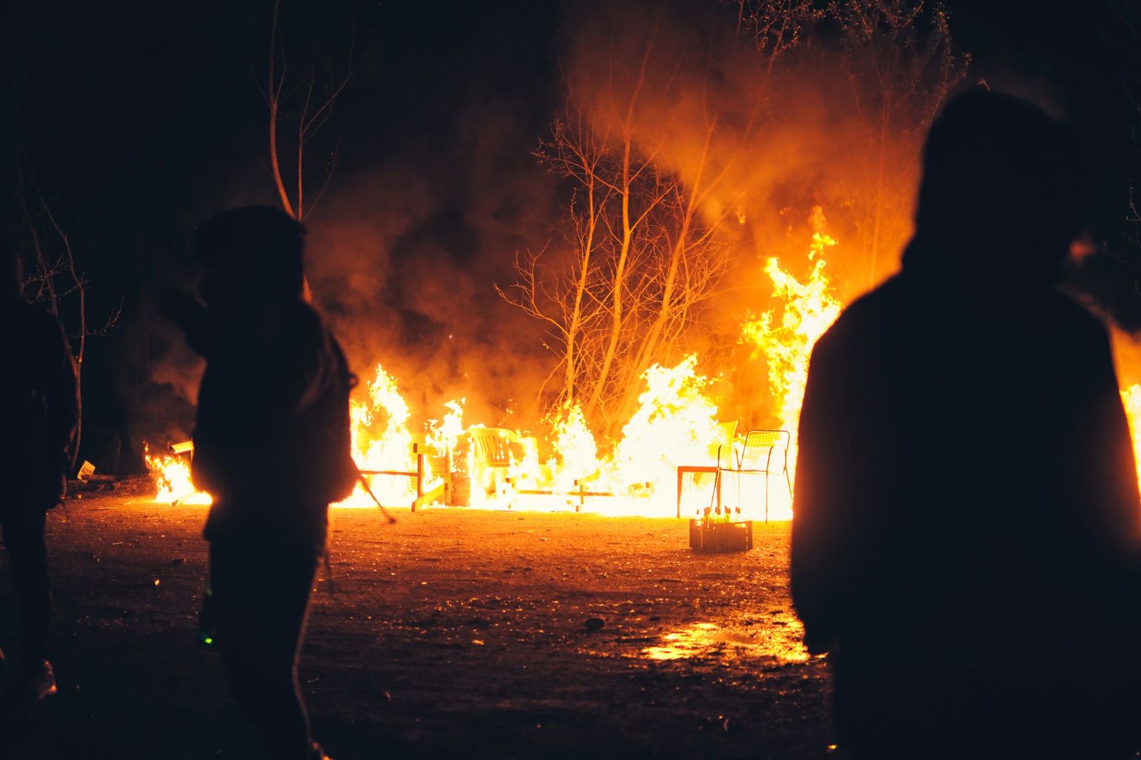 Wildland fire crew silhouetted against flames