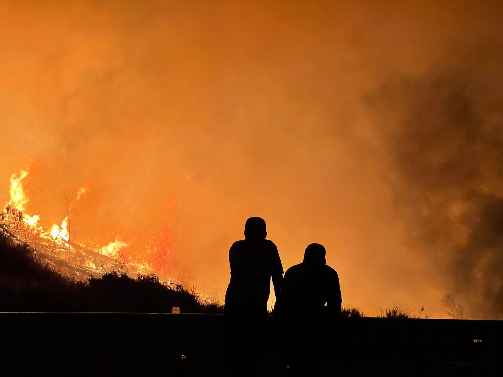 Wildland firefighters silhouetted at a wildfire fire camp