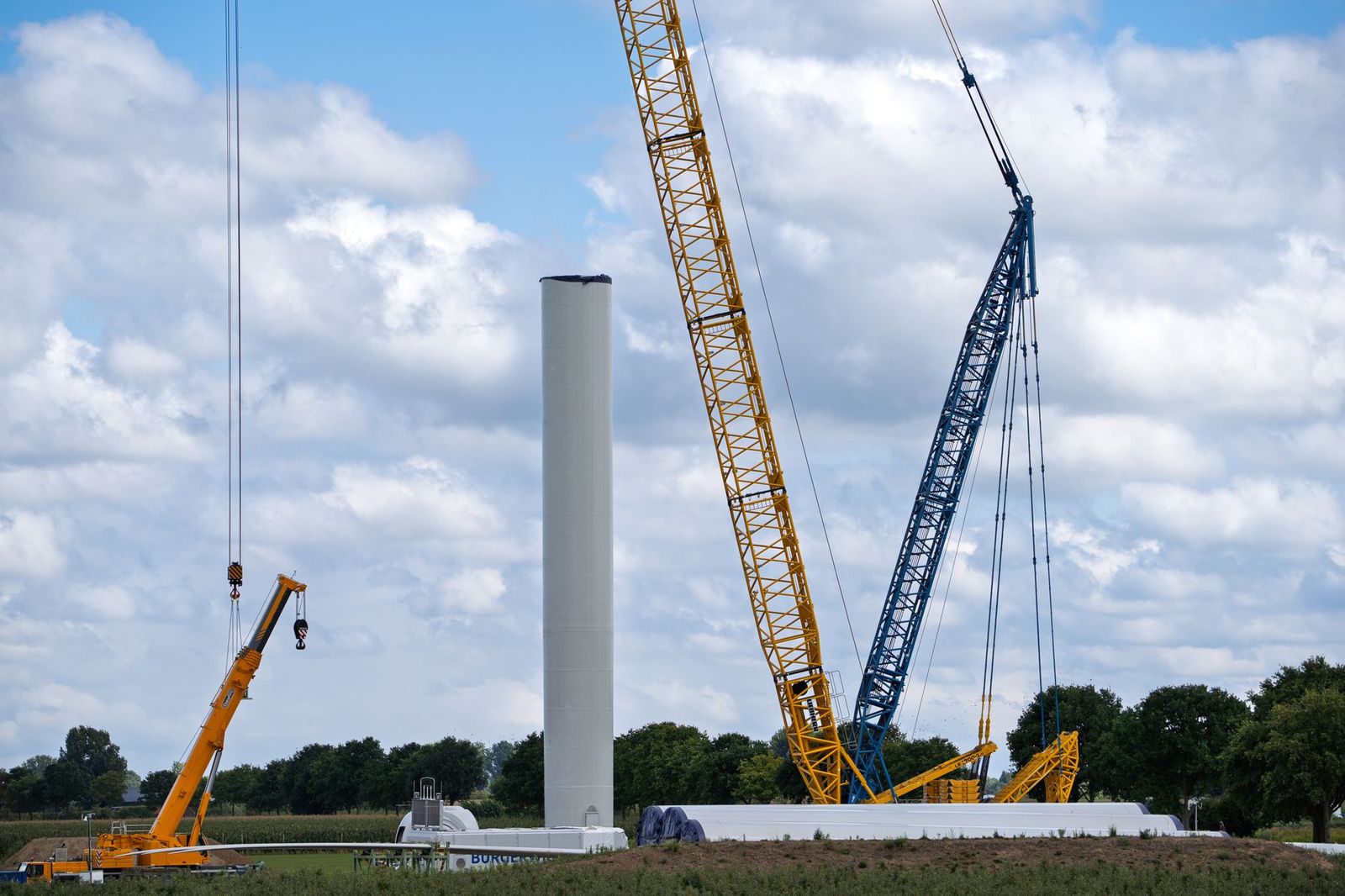 Crane lifting a wind turbine tower section during construction